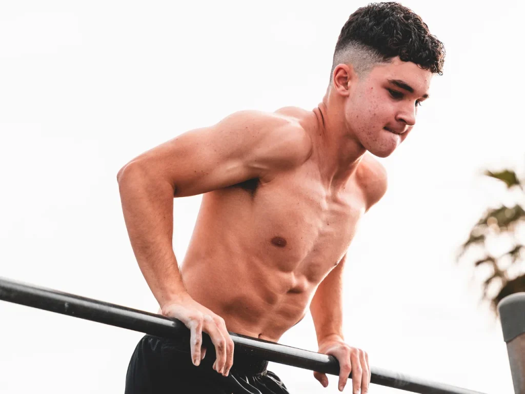 Joven realizando un muscle-up en entrenamiento de calistenia