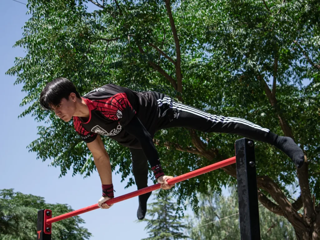 Mario haciendo straddle planche en barra